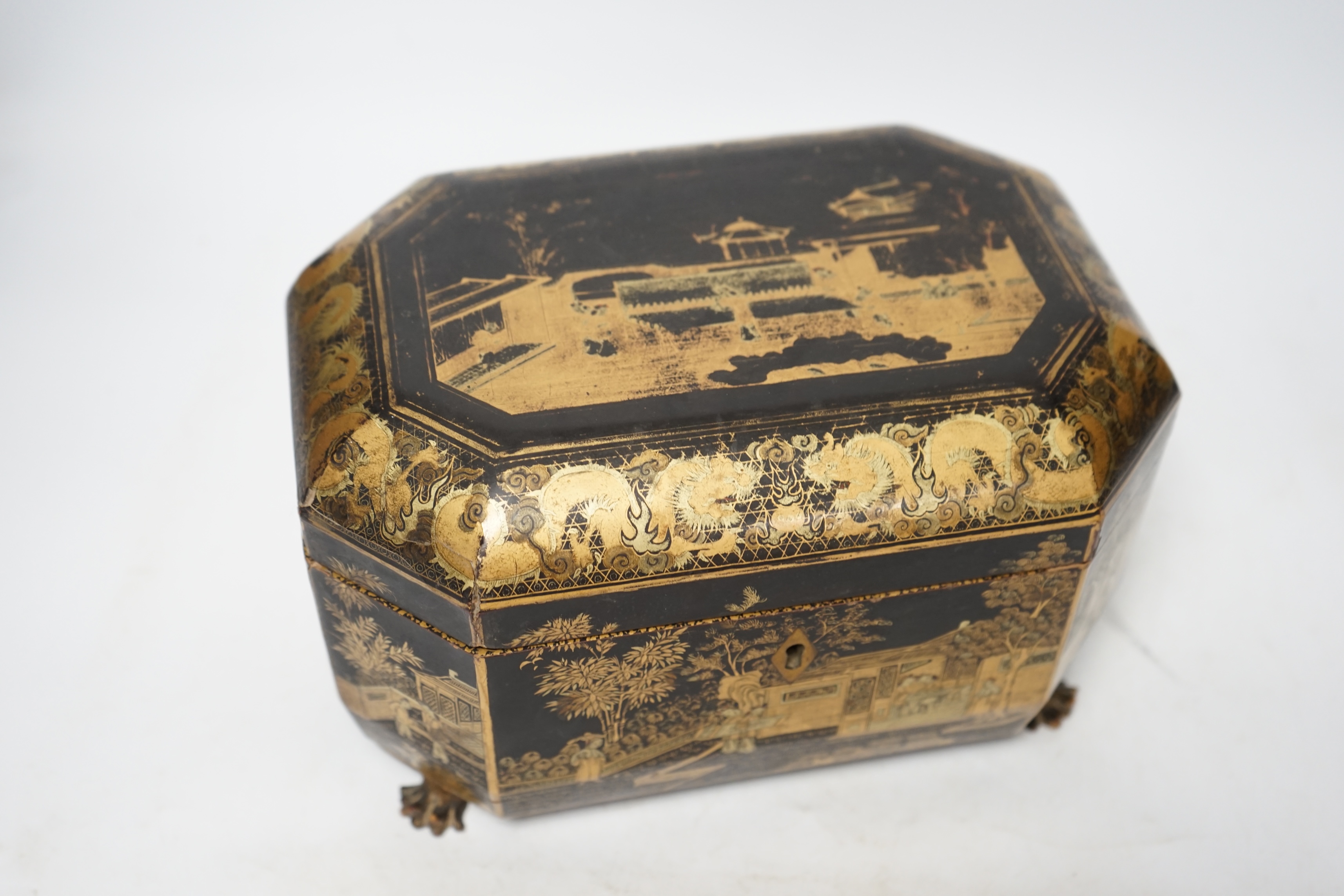 A mid 19th century Chinese export black and gold lacquer tea caddy, retaining engraved pewter tea canisters, raised on paw feet, 26cm wide. Condition - poor